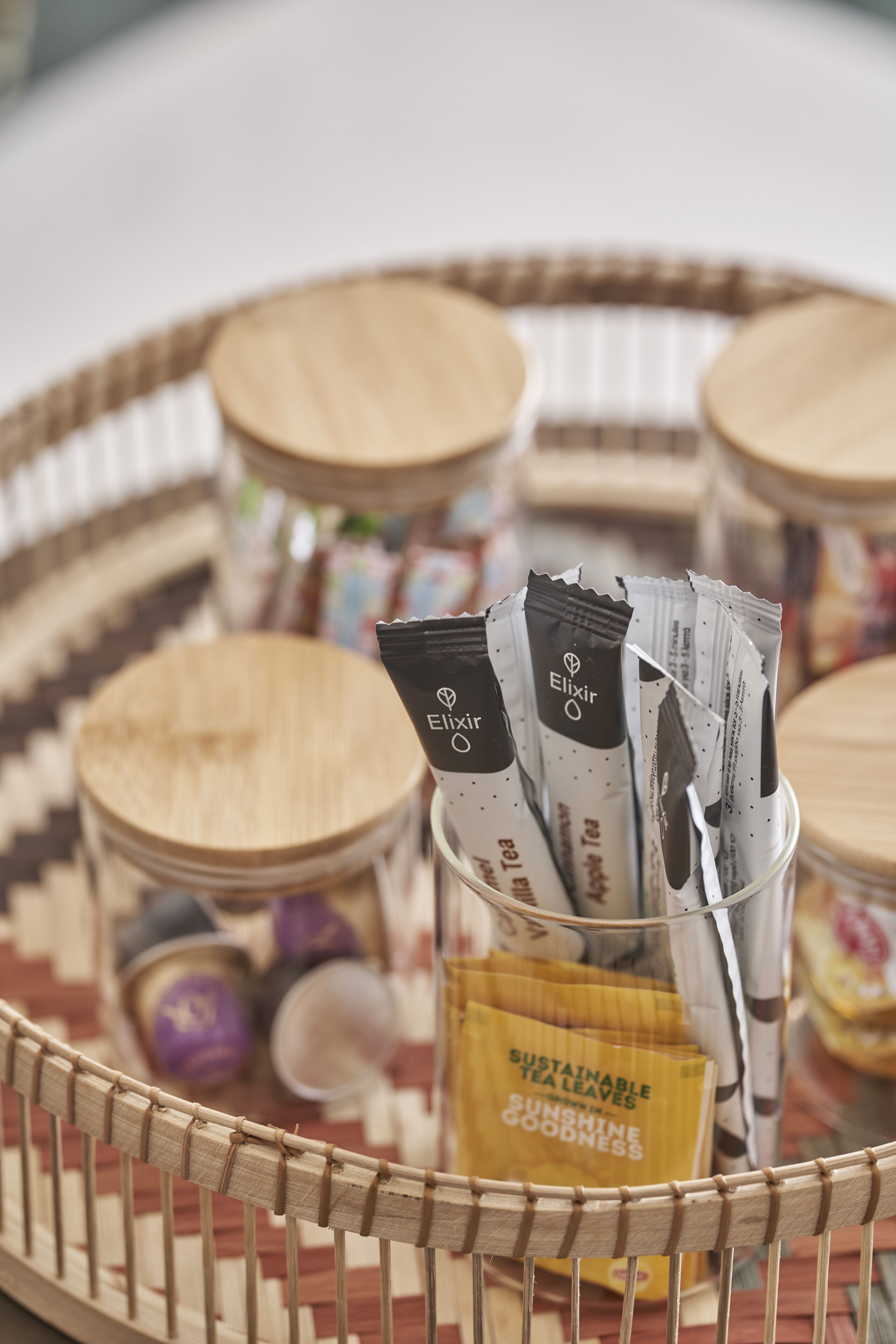 Un panier en osier contenant des sachets de thé et des pots.