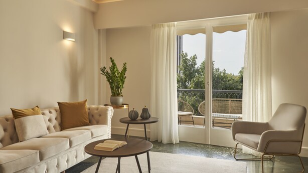 A living room with a sofa, armchair, coffee table, and a potted plant. - Chic n Bright 3 Bd Apt with Hilton View (Athens)