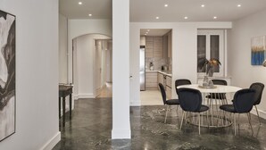 A modern dining area with a round table, black chairs, and a white wall. - Chic n Bright 3 Bd Apt with Hilton View (Athens)