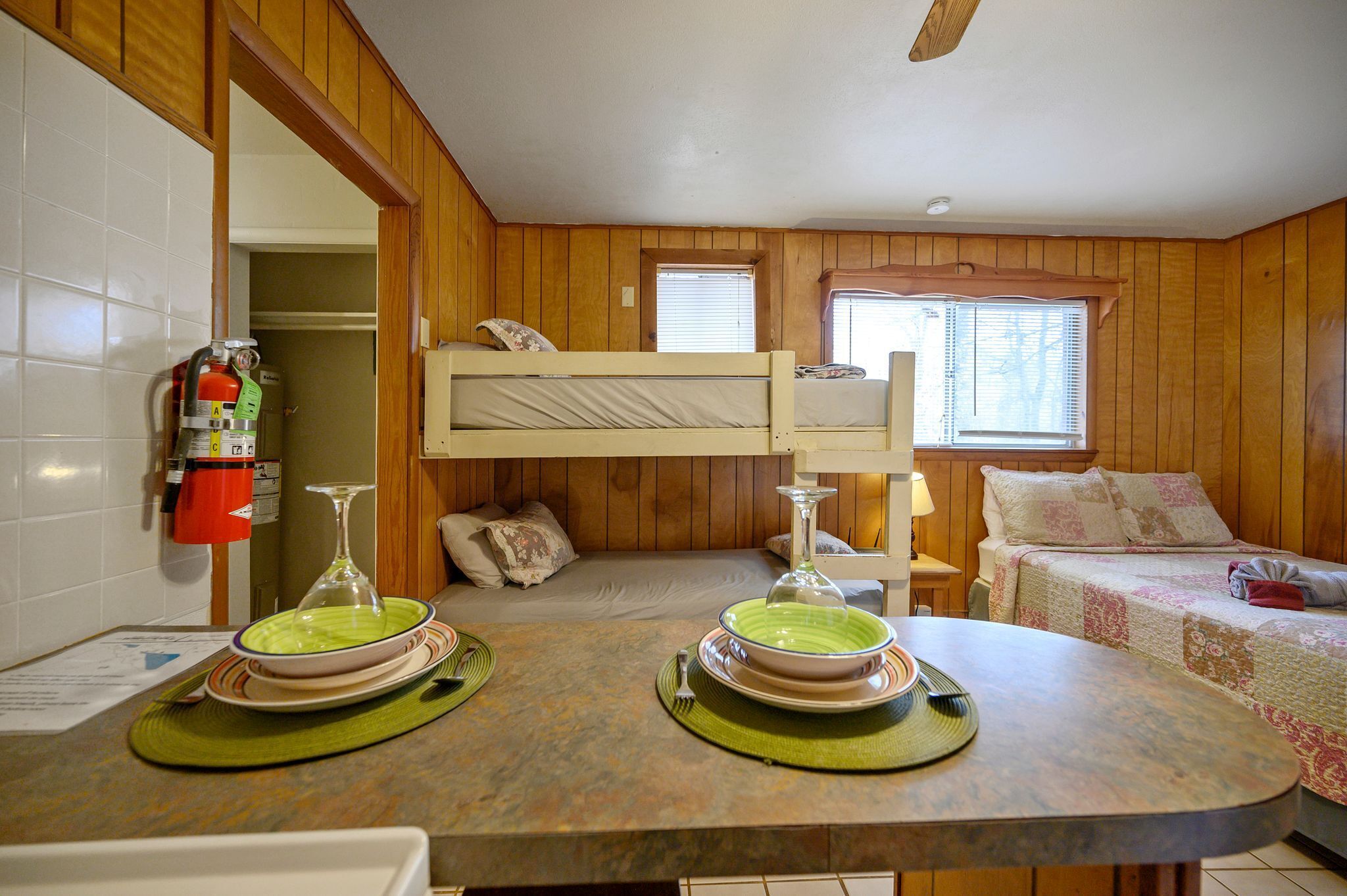 A bunk bed room with a kitchen area.