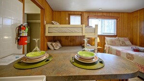 Ein Schlafzimmer mit Etagenbetten und einer Küchenzeile.