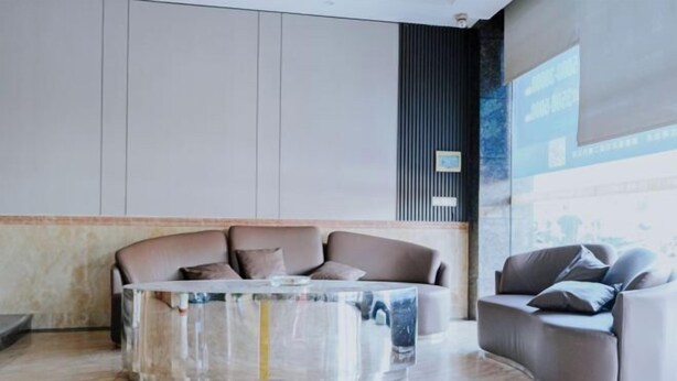 A modern lobby with a curved sofa and a glass coffee table. - Guangzhou New Modern Hotel (Shiling lisha squar) (Guangzhou)