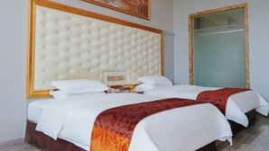 A hotel room with a large tufted headboard, two beds with white bedding and red throw blankets, a painting above the headboard, and a glass door closet. - Guangzhou New Modern Hotel (Shiling lisha squar) (Guangzhou)