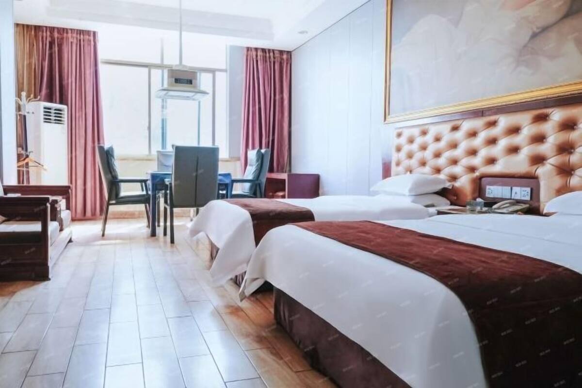 Una habitació d'hotel amb un llit gran, un escriptori i una cadira.
