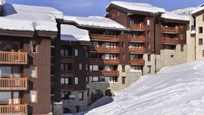 A multi-story hotel with balconies, stone walls, and snow-covered roofs.