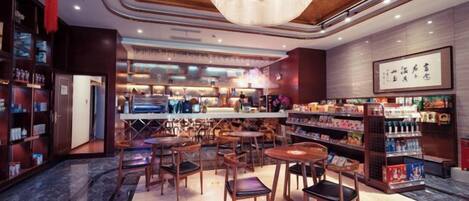 A hotel lobby with a bar area, seating arrangements, and a reception desk.