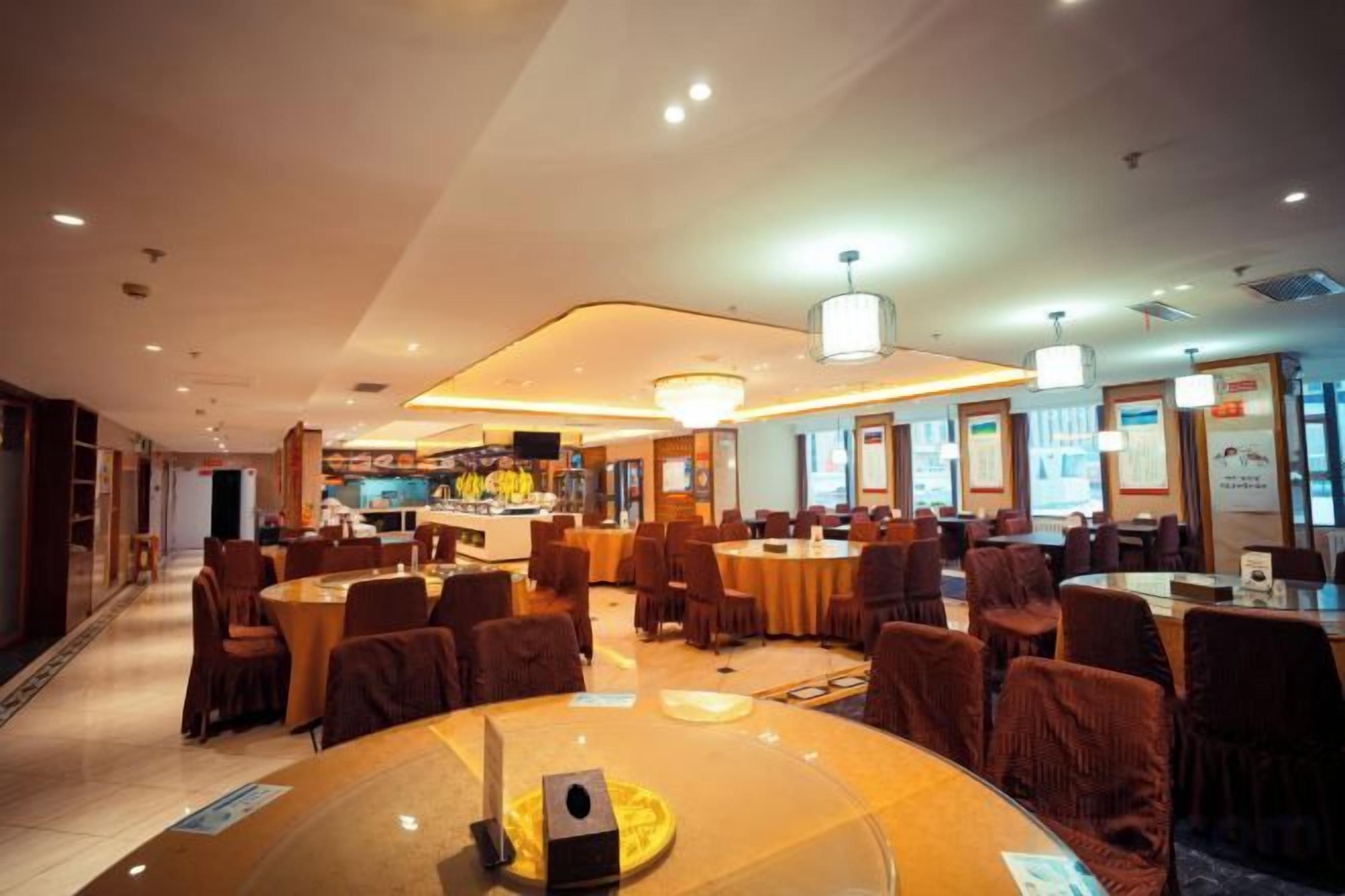 Un amplio vestíbulo de hotel con varias zonas de estar, un bar y una recepción.
