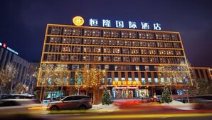A modern hotel building with multiple floors and a prominent sign. - Henglong International Hotel (Karamay)