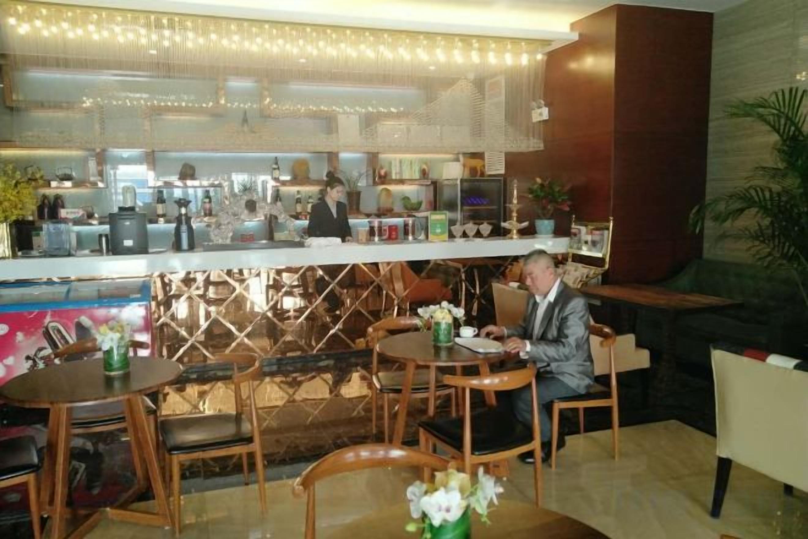 A restaurant with a bar area, seating arrangements, and a counter where staff are serving.