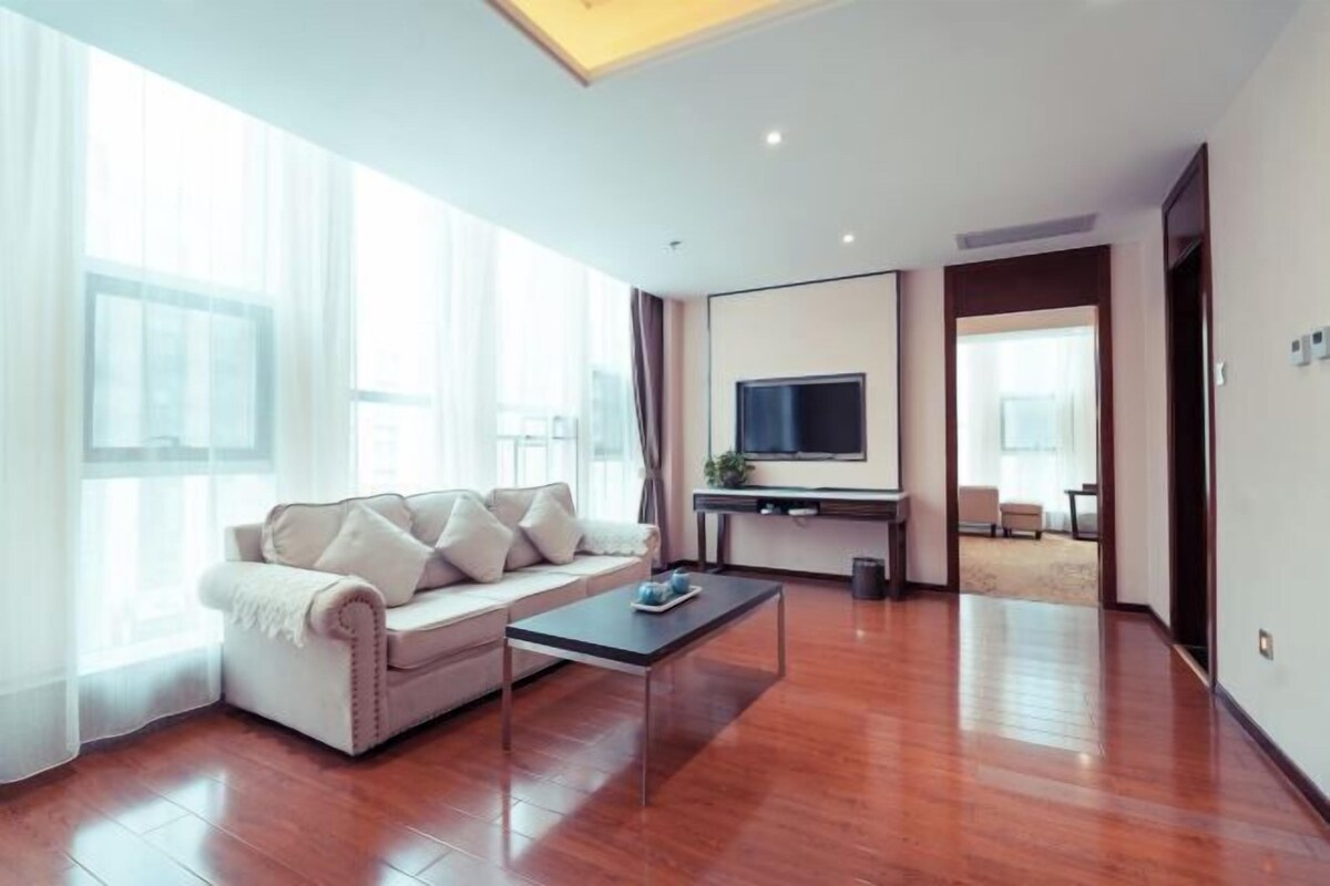 Una sala de estar moderna con un sofá, una mesa de centro y un televisor de pantalla plana.