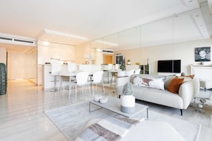 Een moderne woonkamer met een bank, salontafel en een televisie.
