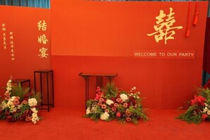 A red backdrop with Chinese characters and a welcome message. - Azalea Garden Hotel (Qianxi)