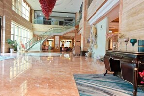 A spacious lobby with a marble floor, a staircase, and a reception desk. - Azalea Garden Hotel (Qianxi)