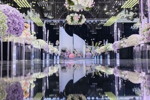 Un sol réfléchissant, agrémenté de compositions florales et surmonté d’une scène centrale.