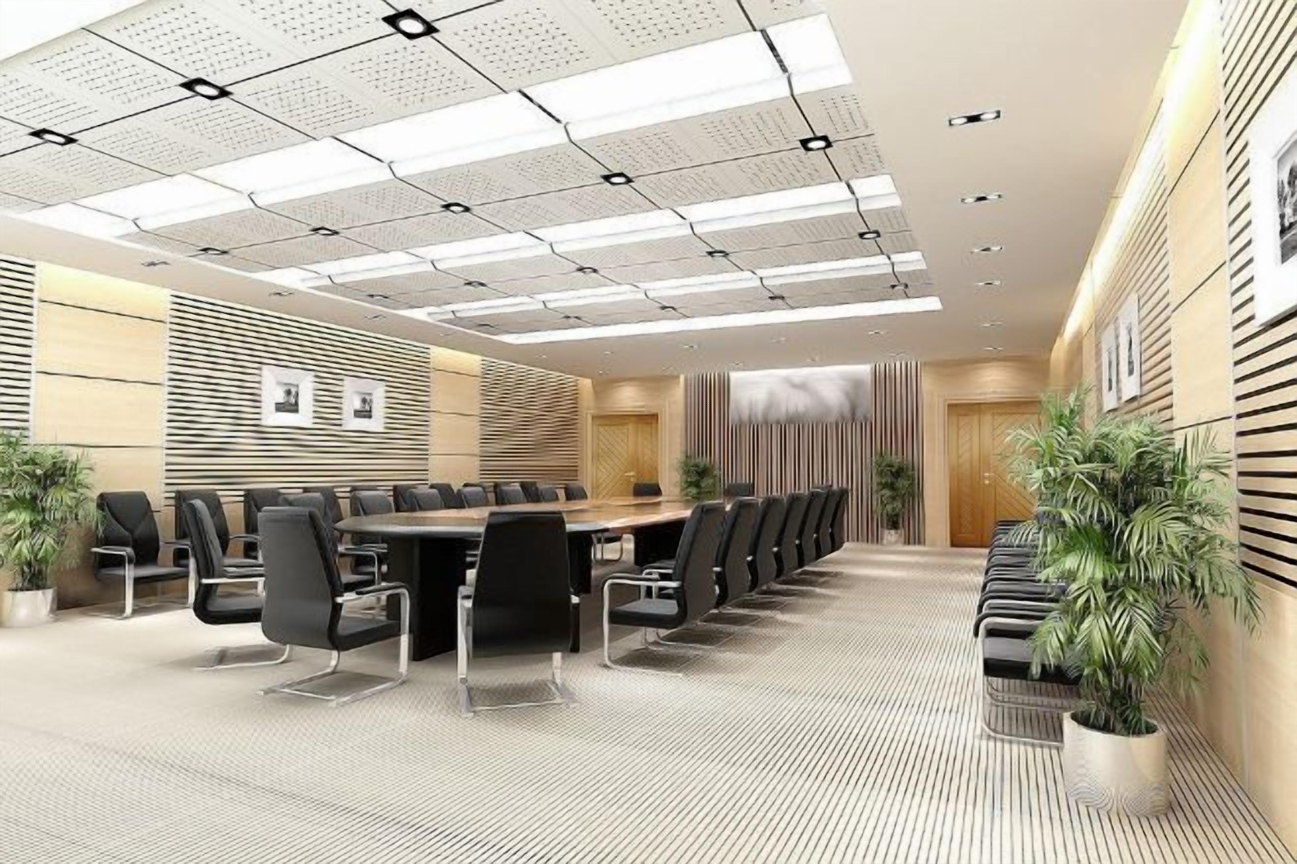 Un salón de conferencias con una larga mesa, sillas y plantas en macetas.