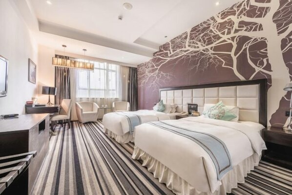 A hotel room with a striped carpet, two beds with white bedding, a large window with curtains, a wall mural, and a desk with a lamp. - Azalea Garden Hotel (Qianxi)
