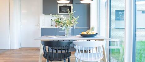 A modern kitchen with dark cabinets, a central island, and pendant lighting.