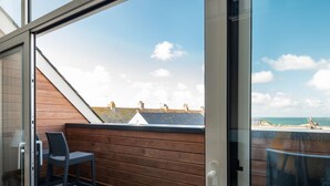 A balcony with a view of the sea, wooden flooring, and a table with chairs. - Church Rooms (Port Isaac)