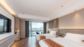 Ein modernes Hotelzimmer mit zwei Betten, einem großen Fenster und Blick auf die Stadt.