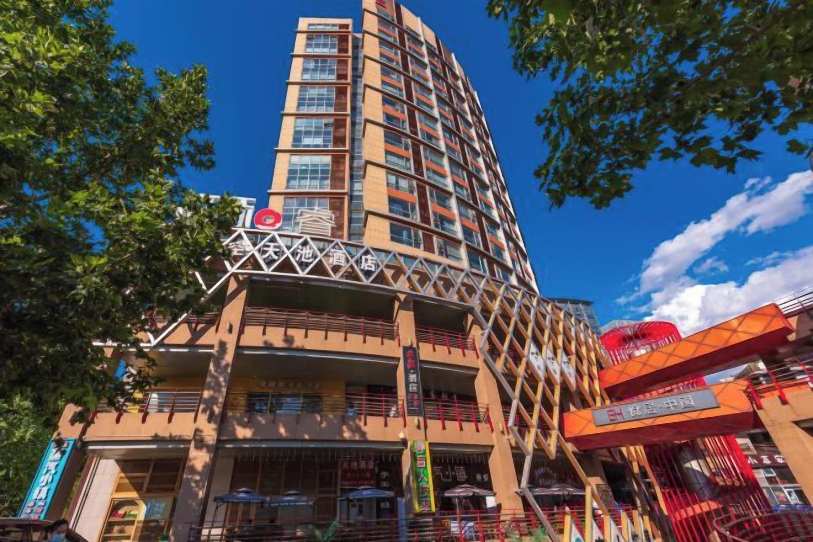 A multi-story hotel with a distinctive curved facade, balconies, and a prominent entrance with a red awning.