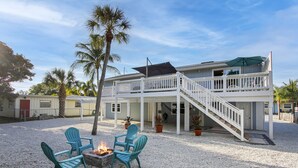 A two-story house with a covered patio, outdoor seating, and a fire pit. - Delightful 2/2 Beach House LBK 5 Min drive to Beach (Longboat Key)