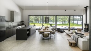 Una cocina moderna con comedor, ventanas amplias y chimenea.