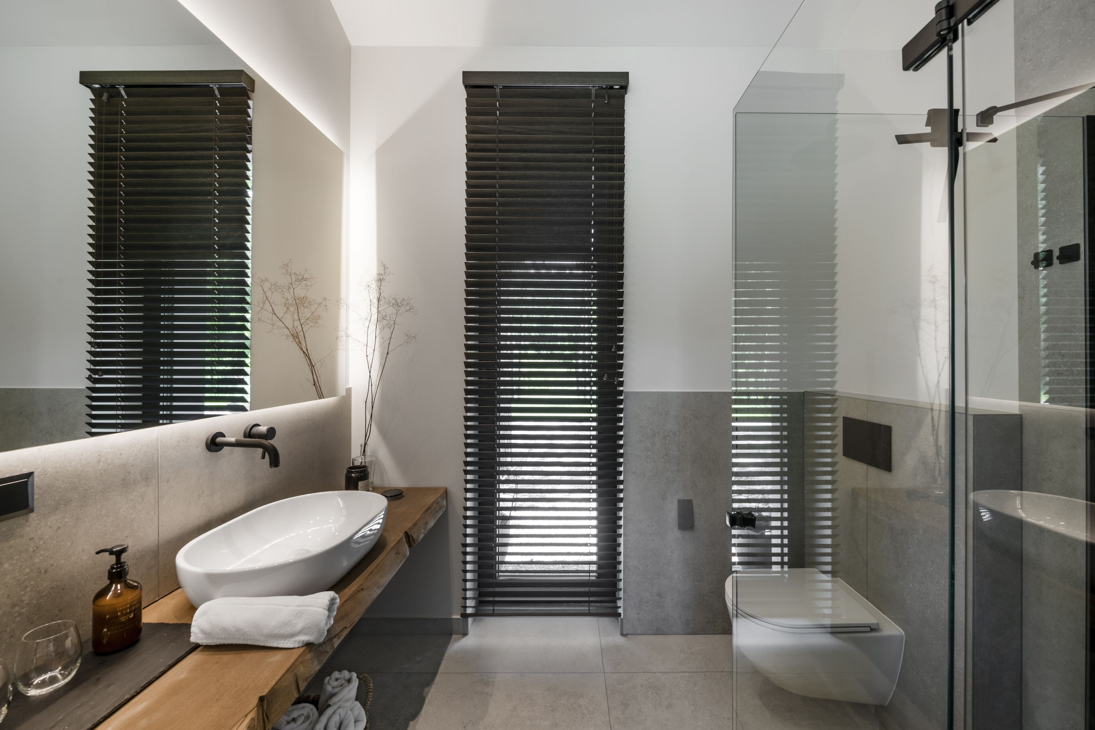 A modern bathroom with a large sink, toilet, and shower area.