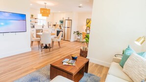 Een moderne woonkamer met een bank, salontafel en televisie.