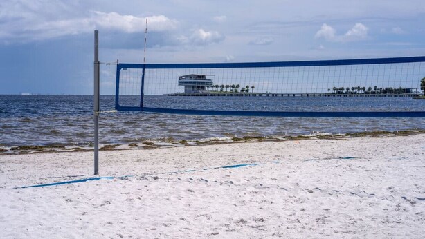 A beach volleyball net with a modern building in the background. - Vinoy Beach getaway, Fun in the Sun Close to bars! (St. Petersburg)