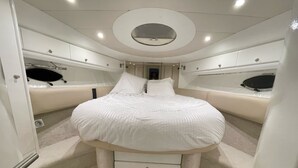 A compact, well-lit bedroom with a round bed, a small bedside table, and a built-in wardrobe. - Yacht 17M Cannes Croisette Port Canto, 3 Bedrooms, air conditioning, tv (Cannes)