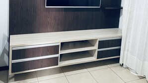 A modern entertainment unit with a flat-screen TV, built-in shelves, and a wooden finish. - Great 2 Bedroom Apartment - Excellent Location (Cuiabá)