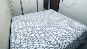 A bedroom with a bed, a wardrobe, and a TV mounted on the wall. - Great 2 Bedroom Apartment - Excellent Location (Cuiabá)