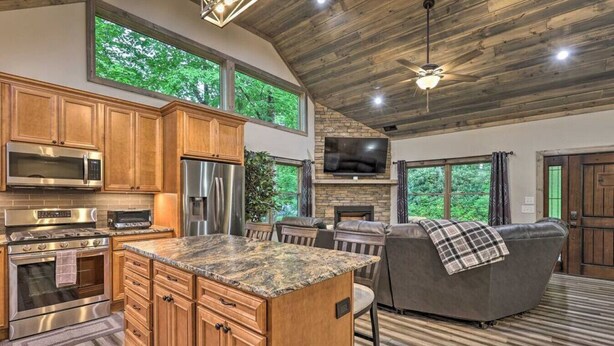 A spacious kitchen with wooden cabinets, a granite countertop, stainless steel appliances, and a large island.