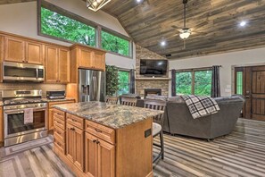 Una cocina amplia con gabinetes de madera, encimera de granito y electrodomésticos de acero inoxidable, además de una isla grande.