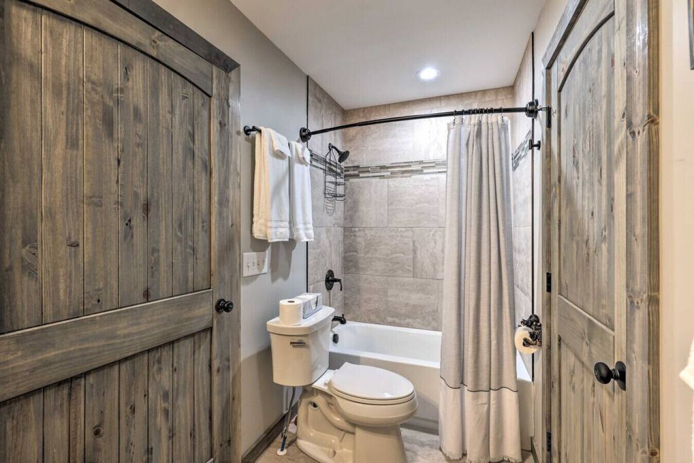 Ein Badezimmer mit Toilette, Badewanne und Duschvorhang.