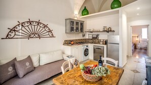 Une cuisine moderne équipée d’un lave-linge, d’un réfrigérateur et d’un coin repas avec une table et des chaises.