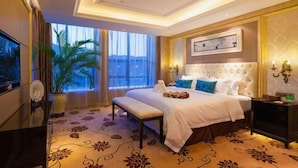 A hotel room with a large bed, a television, a potted plant, and a view of the outdoors. - Celebrity Hotel (Baokang)