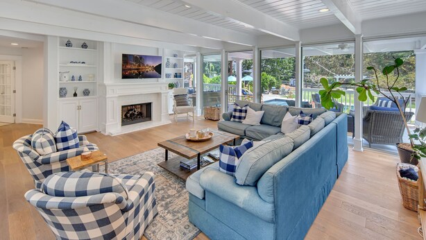 A spacious living room with a fireplace, blue and white checkered furniture, and a large window overlooking a garden. - A Slice of Heaven near Rancho Santa Fe (Del Mar)