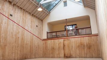 An indoor squash court with wooden walls and a sloped ceiling.