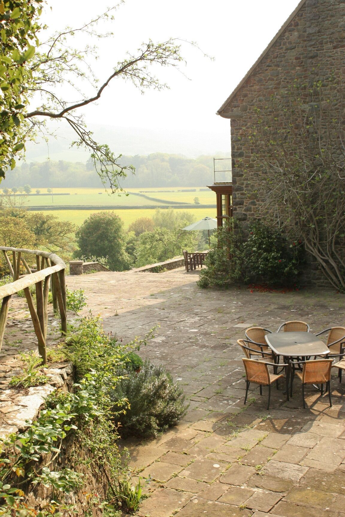 A stone building with a stone staircase leading to a patio area.