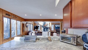 A spacious kitchen with wooden cabinets, a granite countertop, and a built-in oven. - Large rustic style home in gated community: Fire Pit - Lake - Beach - pools! (Gouldsboro)