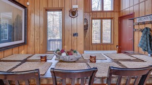 A wooden interior with a dining table set for four, a mounted deer head, and a sign that reads "BE OUR Guests". - Large rustic style home in gated community: Fire Pit - Lake - Beach - pools! (Gouldsboro)