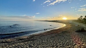 A beach with a clear sky and the sun setting on the horizon. - Casares Beach Doña Julia Golf Apartment With Private Garden Direct Pool Access (Casares)