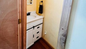 A small bathroom with a white sink, a mirror, and a towel ring on the wall. - Slick Rock Retreat (Moab)
