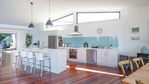 Eine moderne Küche mit Kochinsel, Edelstahlgeräten und einem großen Fenster.