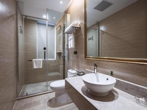 Un baño moderno con ducha envuelta en cristal, inodoro blanco y un espejo grande.