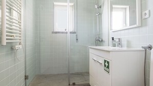 Une salle de bain avec une douche, un lavabo et des toilettes.