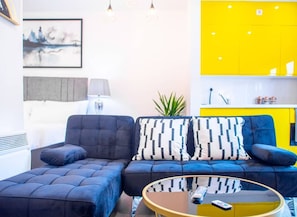 Relax in a stylish living area with a sofa, coffee table, and potted plant.