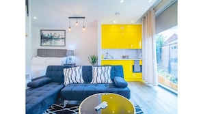 Relax in this stylish living room with a sofa, coffee table, and large window offering a view of the outdoors.