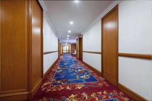 A hotel hallway with a carpeted floor, wooden paneling, and a series of doors leading to rooms. - ZHEJIANG BUILDING HOTEL BEIJING (Beijing)